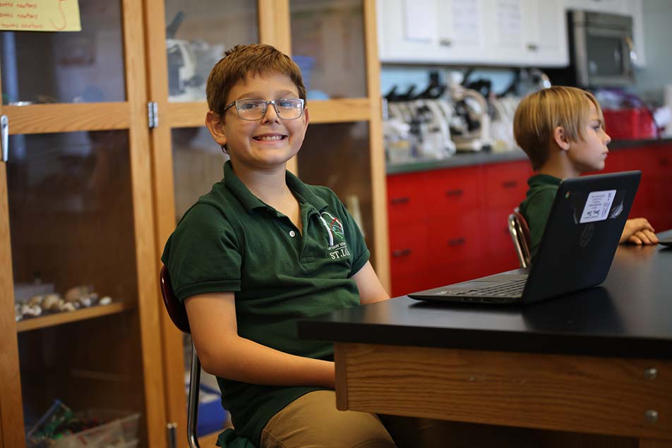student in classroom smiling at camera