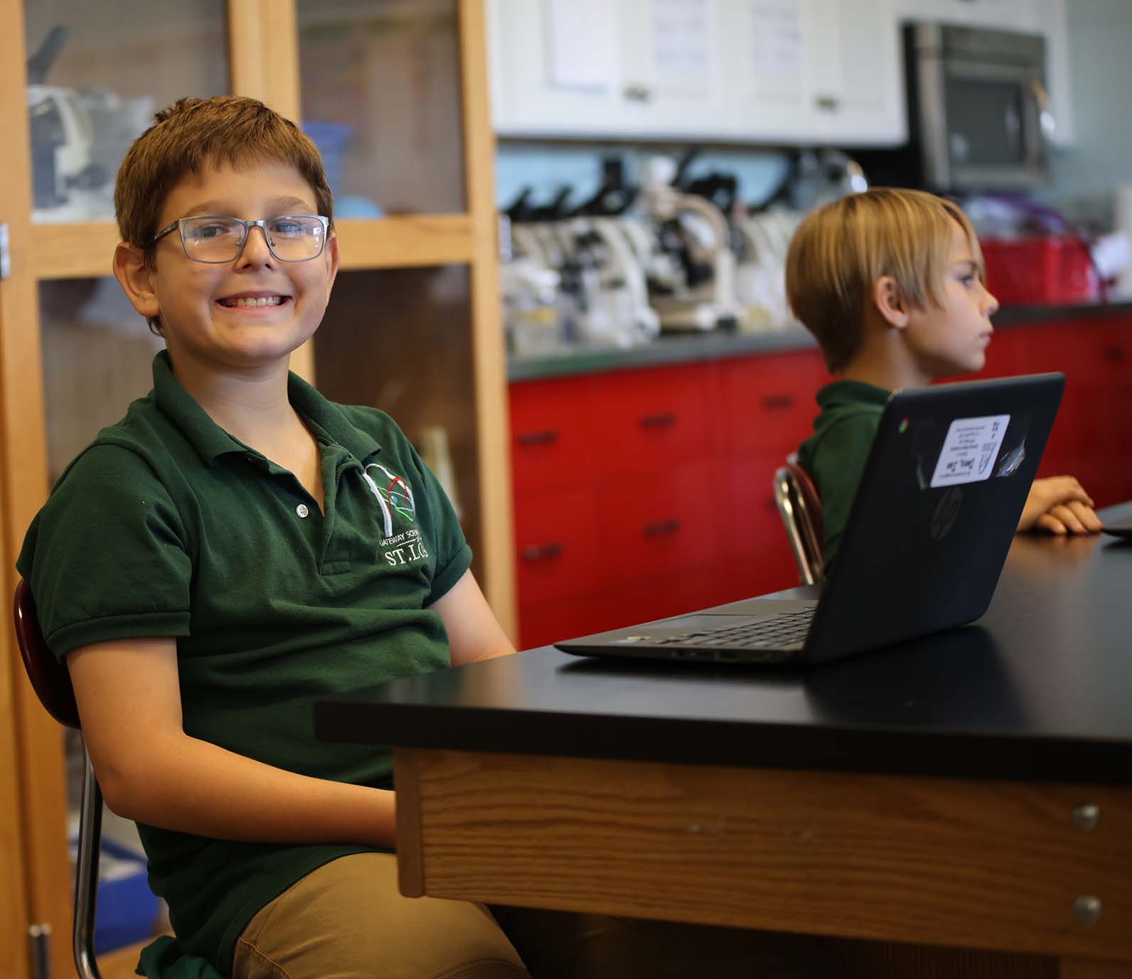 GSA St. Louis Smiley student wearing headphones uses a laptop in class